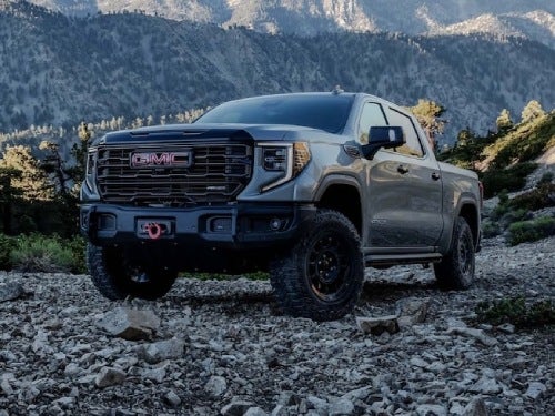 2024 GMC Sierra 1500 AT4X exterior view of truck parked in rocks with mountains in background
