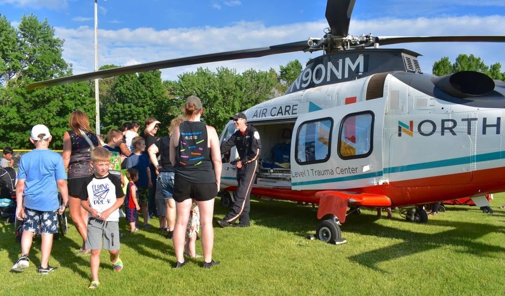 Faribault residents observing a demonstration of a police helicopter at the Safe Summer Kickoff