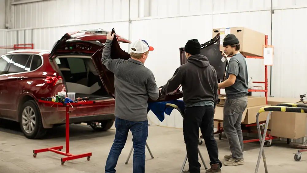 Abra Collision technicians installing a new side panel